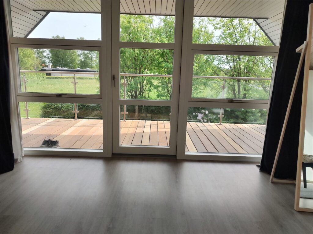 Stue med store vinduer og udsigt til altan