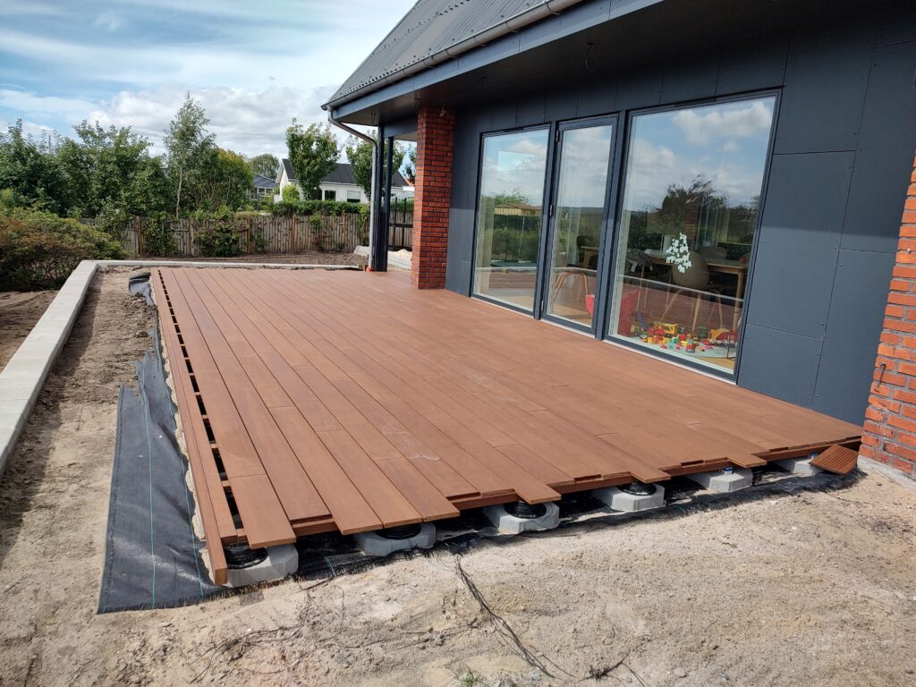 Ny træterrasse under opførelse ved moderne hus