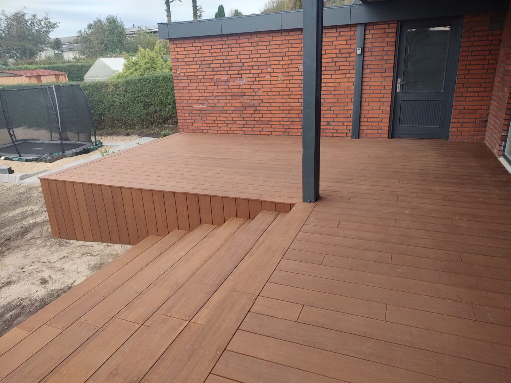 Ny træterrasse ved murstenshus med trin