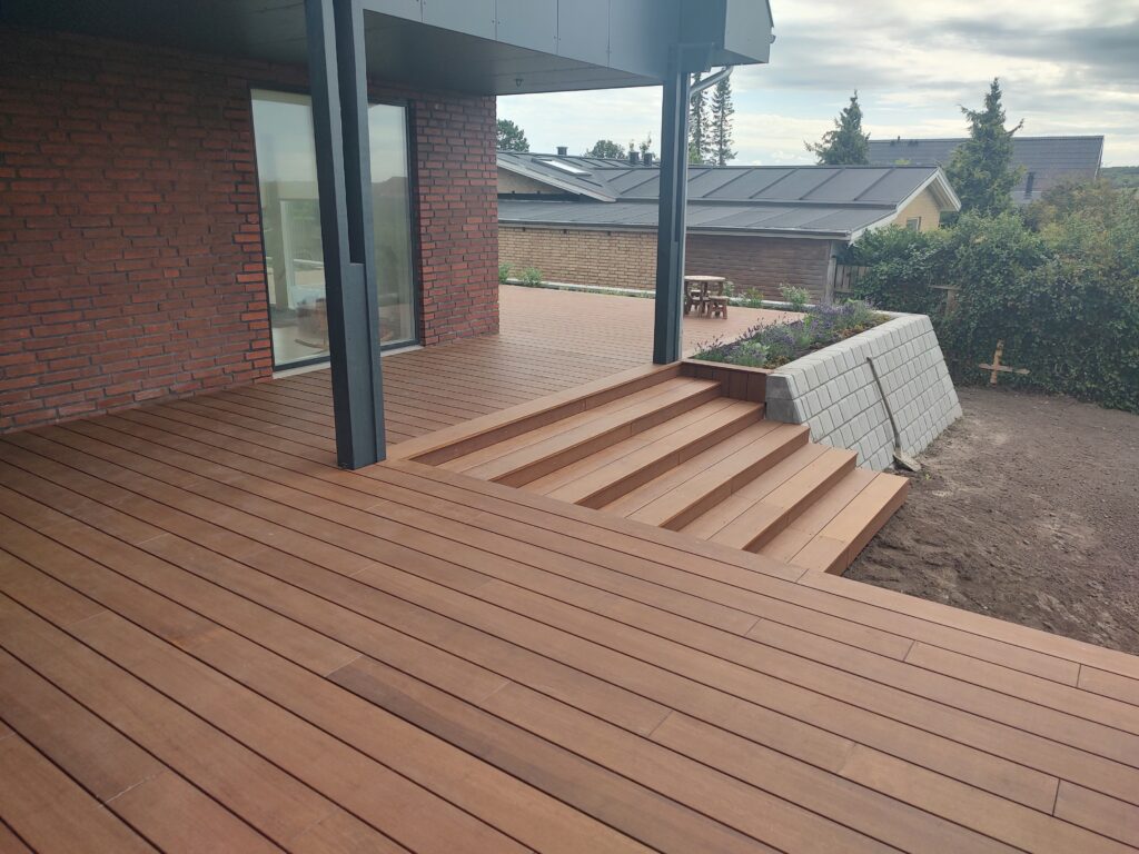 Moderne træterrasse ved murstenshus med trapper